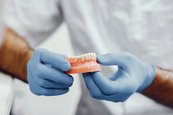 A dental technician hand-finishing a restoration in the in-house laboratory